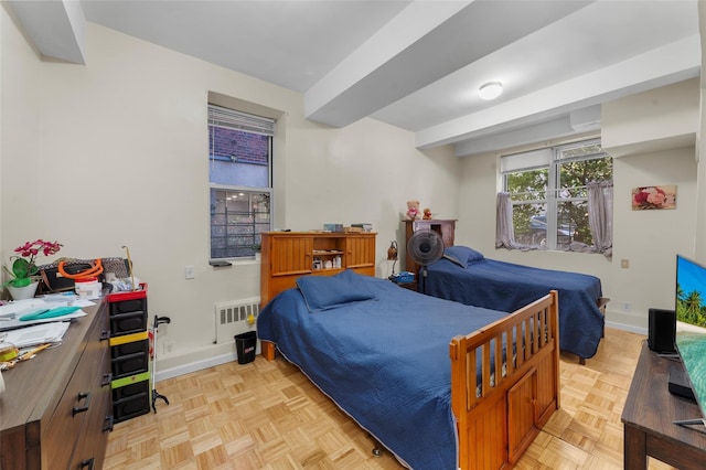 bedroom with radiator heating unit and light parquet floors