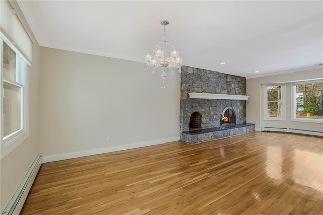 unfurnished living room with a chandelier, a stone fireplace, crown molding, and a baseboard heating unit