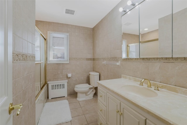 full bathroom with vanity, tile walls, tile patterned flooring, radiator heating unit, and toilet