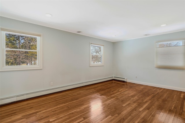 spare room featuring hardwood / wood-style floors and a baseboard radiator