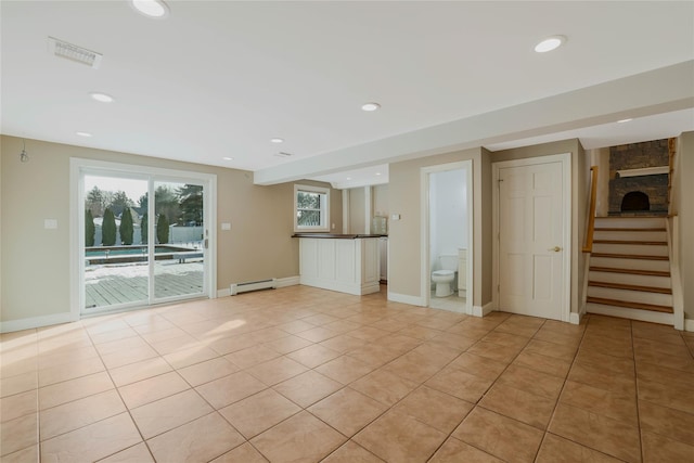 unfurnished living room with light tile patterned floors and a baseboard radiator