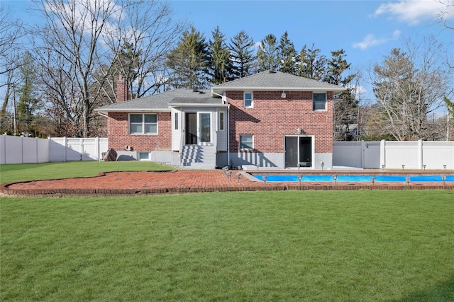 back of house featuring a fenced in pool and a yard