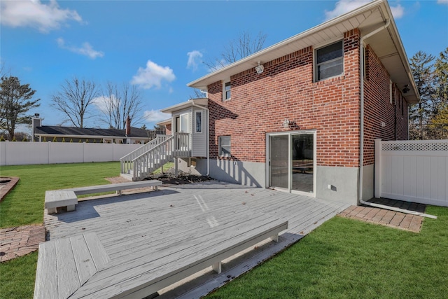 back of property featuring a lawn and a wooden deck