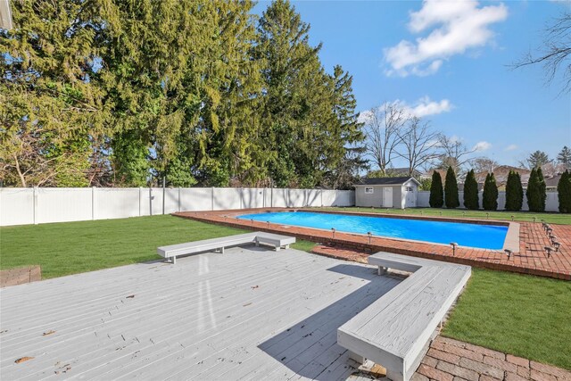 view of swimming pool featuring a shed, a deck, and a yard