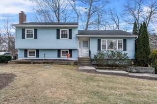 tri-level home with a front lawn