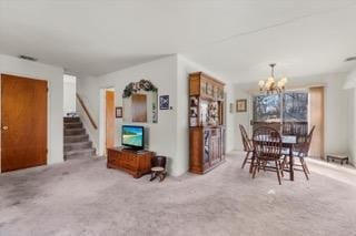 dining room with an inviting chandelier and light colored carpet