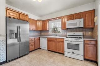 kitchen featuring backsplash and white appliances