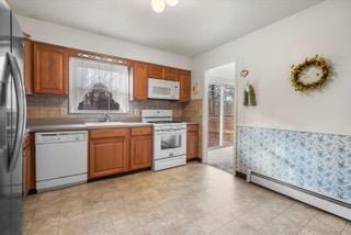 kitchen with sink, white appliances, and a baseboard radiator