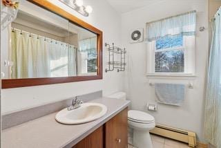 bathroom with toilet, vanity, tile patterned floors, and a baseboard radiator