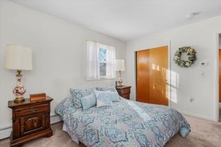 carpeted bedroom with baseboard heating