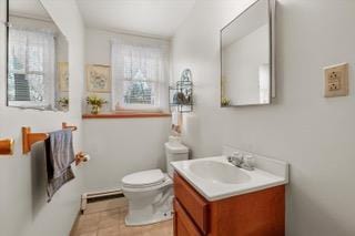 bathroom with toilet, a baseboard heating unit, plenty of natural light, and vanity