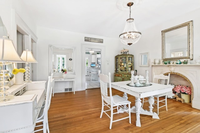 45 Shore Rd, East Setauket, NY 11733 - dining space featuring light wood-style floors and a chandelier