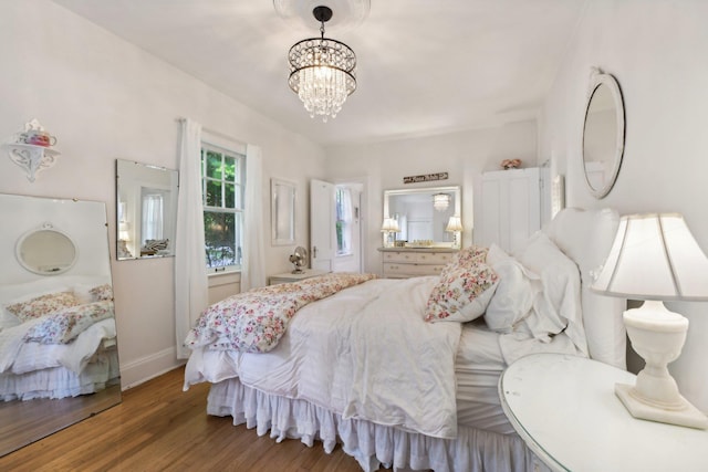 bedroom with an inviting chandelier and hardwood / wood-style flooring