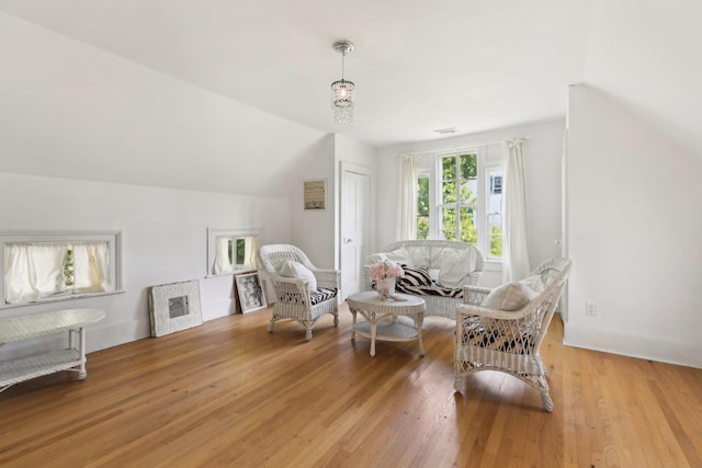 sitting room featuring wood-type flooring and vaulted ceiling