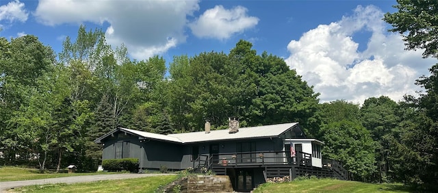 rear view of house featuring a yard and a wooden deck