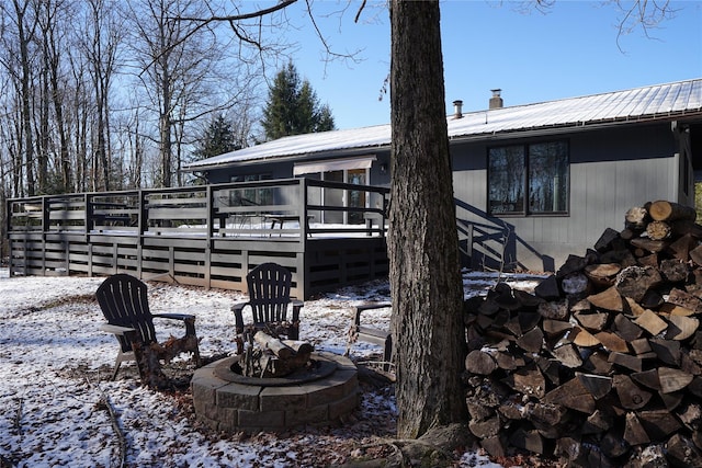 snow covered property with a fire pit and a deck