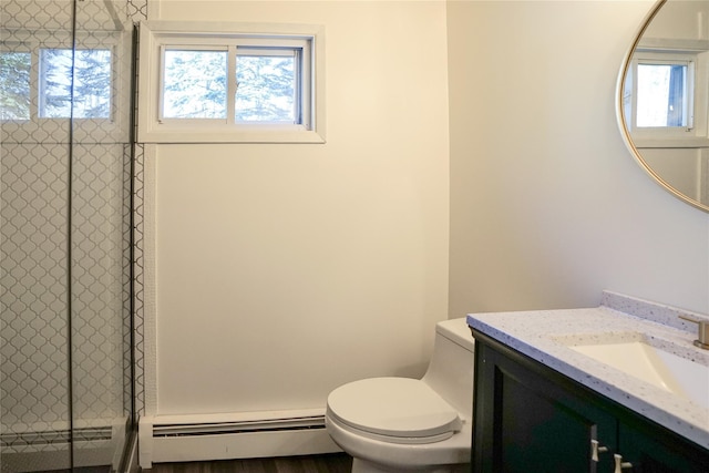 bathroom featuring vanity, toilet, baseboard heating, and a shower with shower door