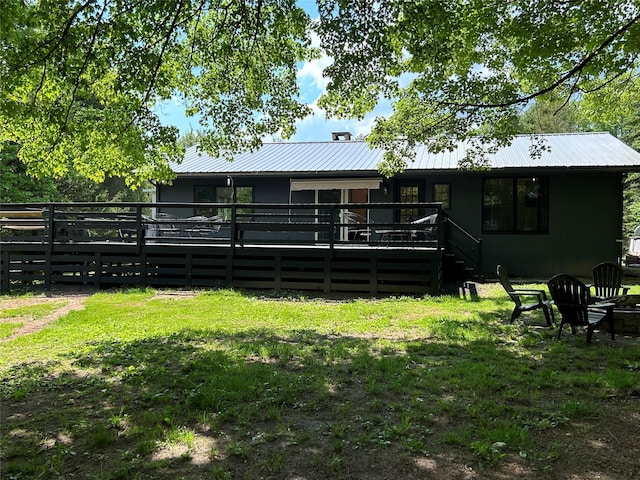 back of house featuring a wooden deck and a lawn