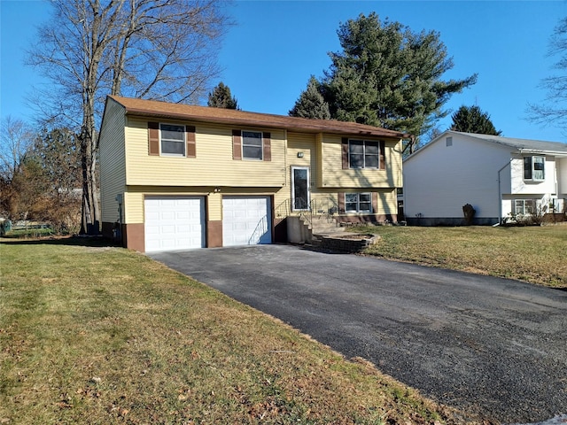 raised ranch featuring a garage and a front lawn