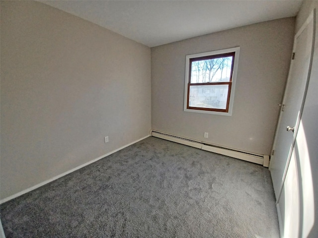 carpeted spare room with a baseboard heating unit