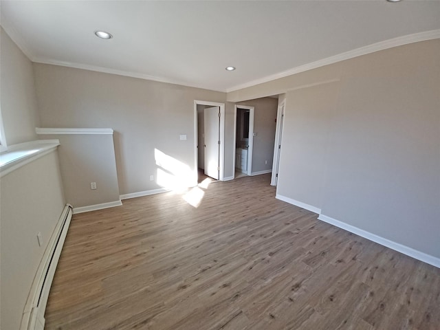 empty room featuring light hardwood / wood-style flooring, a baseboard radiator, and ornamental molding