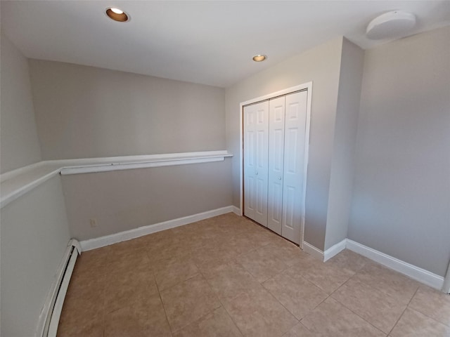 unfurnished bedroom featuring a baseboard radiator and a closet