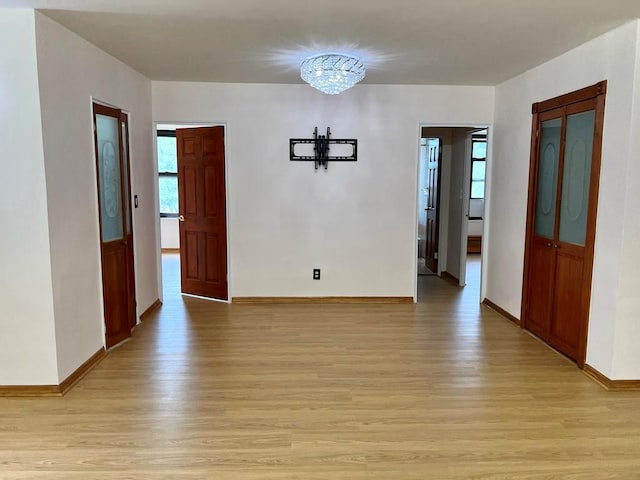 unfurnished room featuring light hardwood / wood-style floors and a chandelier