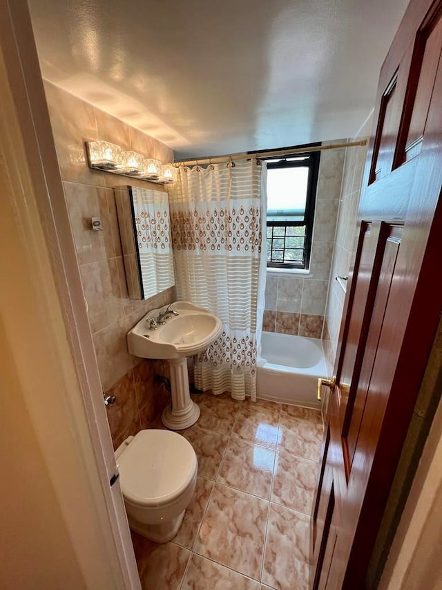 full bathroom featuring sink, toilet, tile walls, and shower / tub combo with curtain