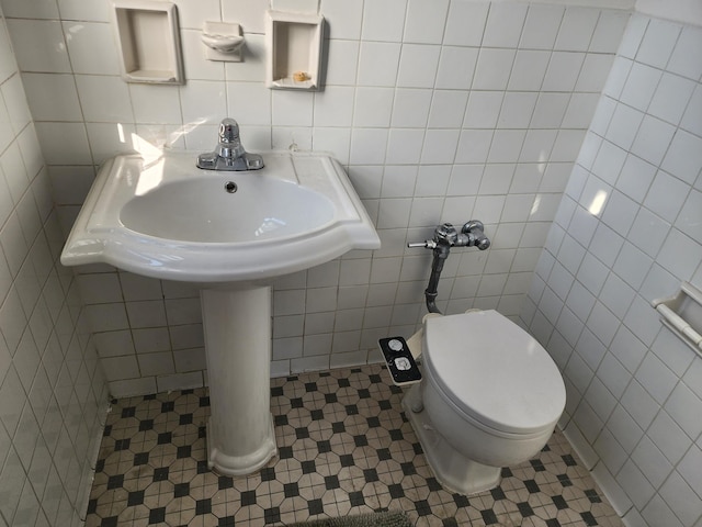 bathroom featuring tile patterned floors, tile walls, and toilet