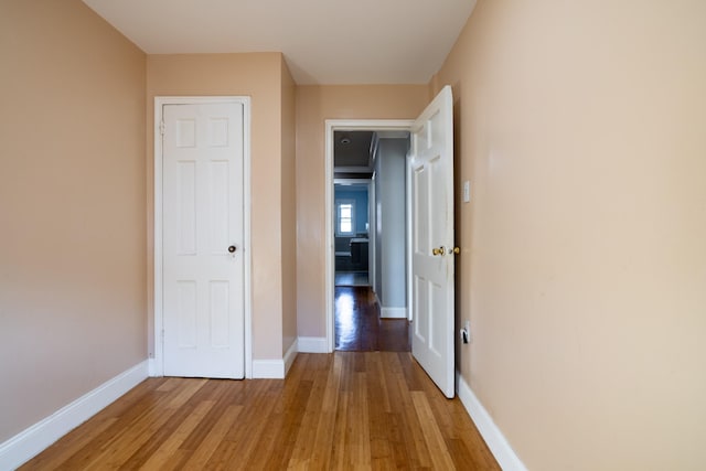 corridor with hardwood / wood-style floors