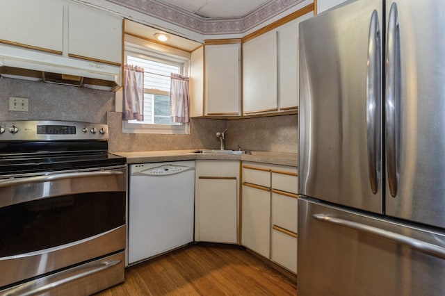 kitchen featuring backsplash, sink, light hardwood / wood-style flooring, white cabinetry, and stainless steel appliances