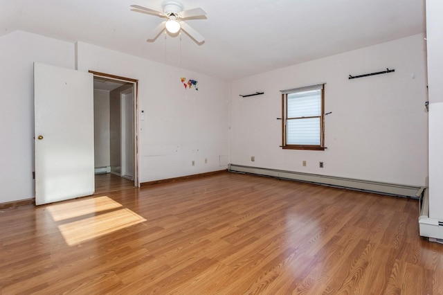 spare room with baseboard heating, ceiling fan, and light wood-type flooring