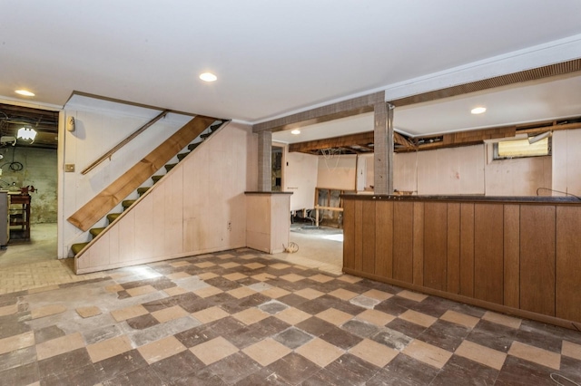 basement featuring wood walls, indoor bar, and dark colored carpet