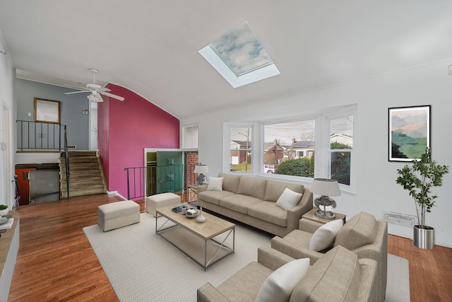 living room with wood-type flooring, lofted ceiling with skylight, and ceiling fan