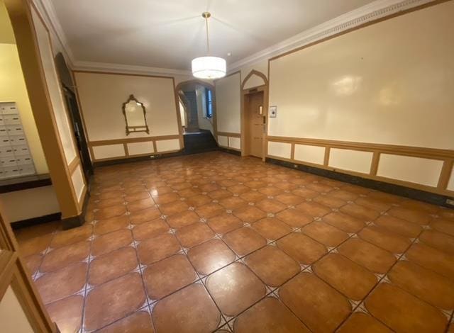 basement featuring crown molding and tile patterned flooring