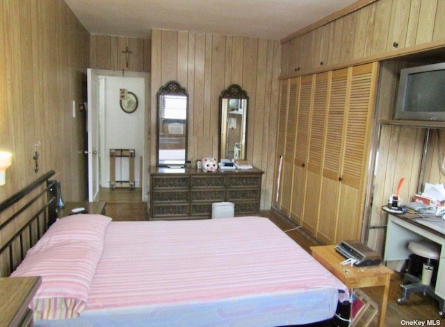 bedroom with a closet and wood walls