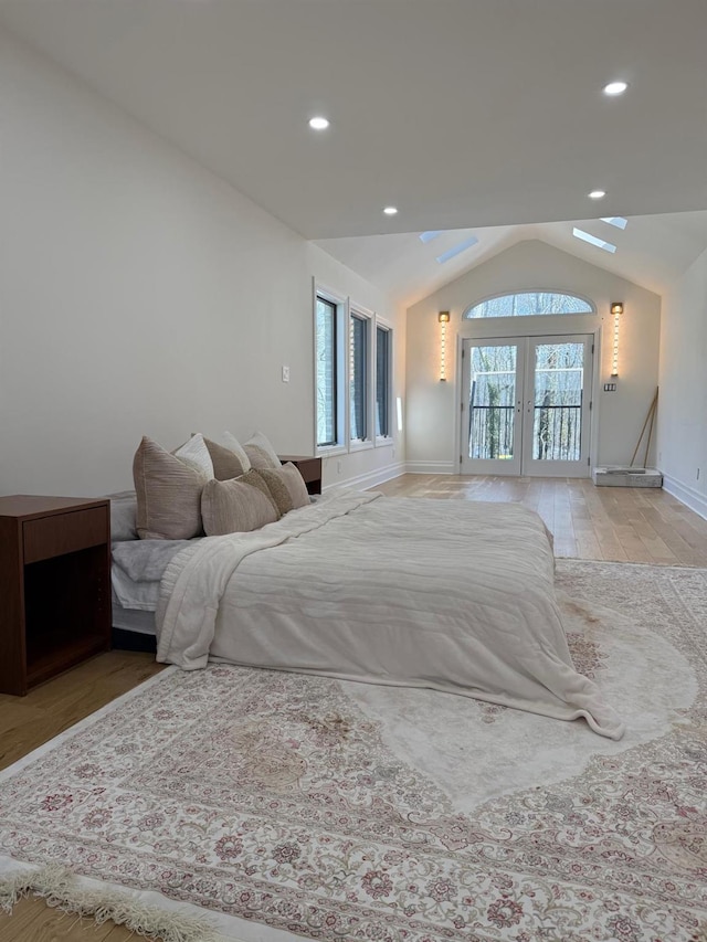 bedroom with french doors, access to outside, recessed lighting, vaulted ceiling with skylight, and baseboards