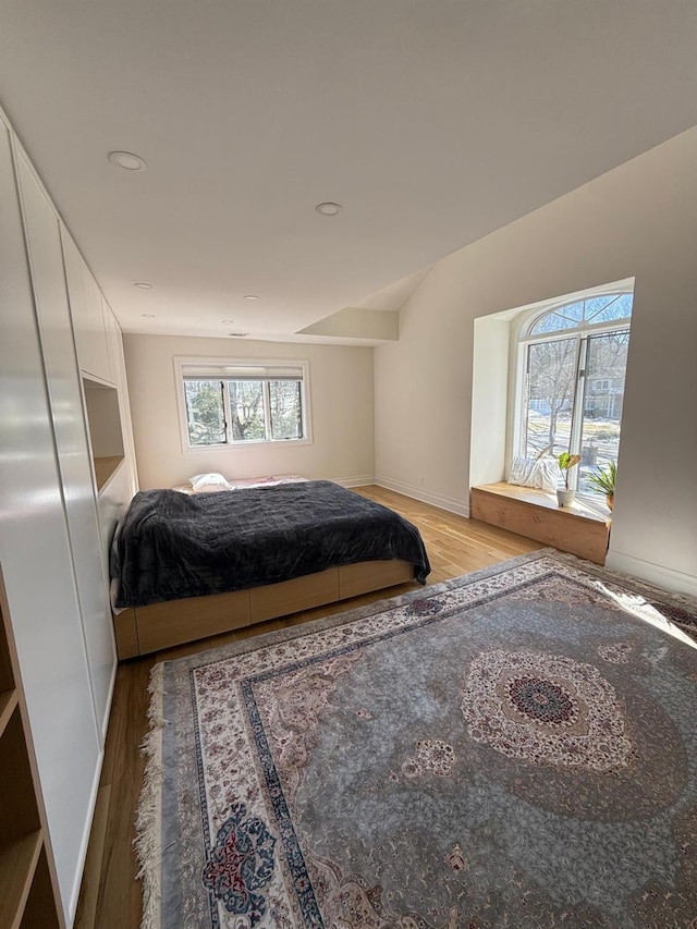 bedroom featuring lofted ceiling, recessed lighting, light wood-type flooring, and baseboards