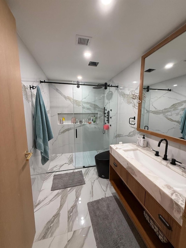 full bath with marble finish floor, a marble finish shower, visible vents, vanity, and stone wall