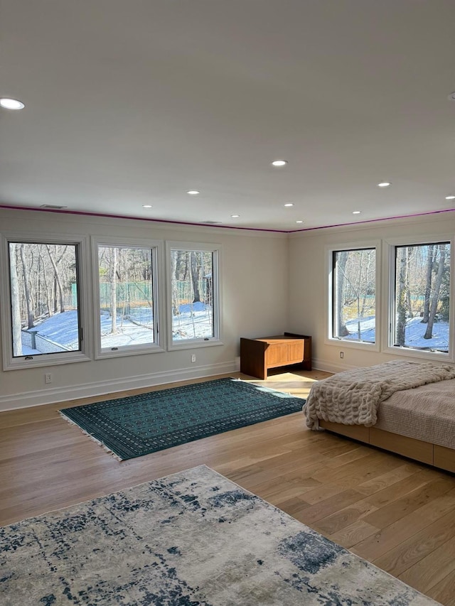 bedroom featuring recessed lighting, multiple windows, and wood finished floors