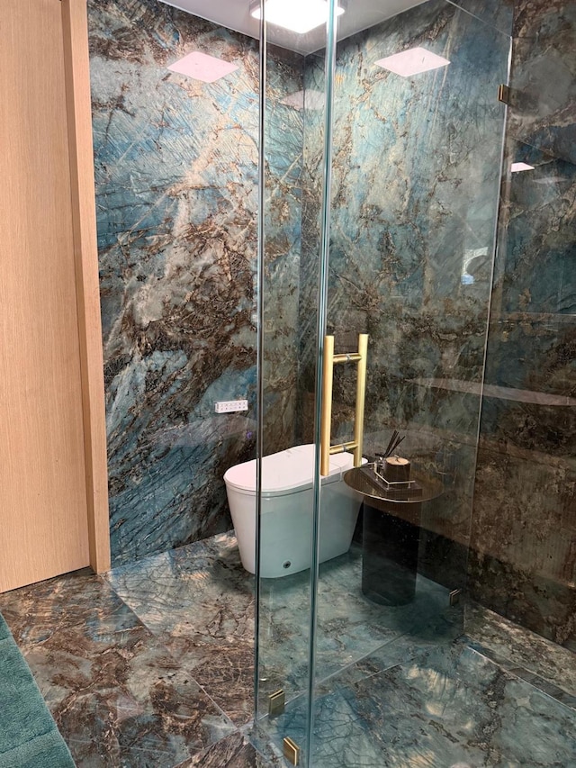 full bath with marble finish floor, toilet, tile walls, and a marble finish shower