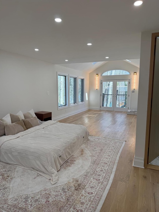 unfurnished bedroom featuring light wood-style flooring, recessed lighting, baseboards, vaulted ceiling, and french doors