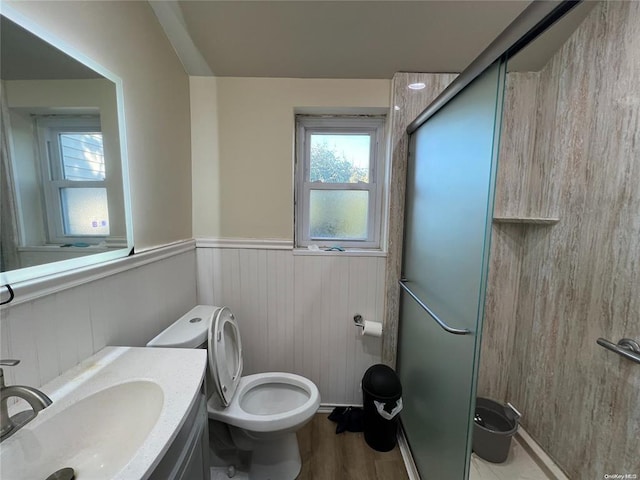 bathroom with hardwood / wood-style floors, vanity, wood walls, toilet, and an enclosed shower