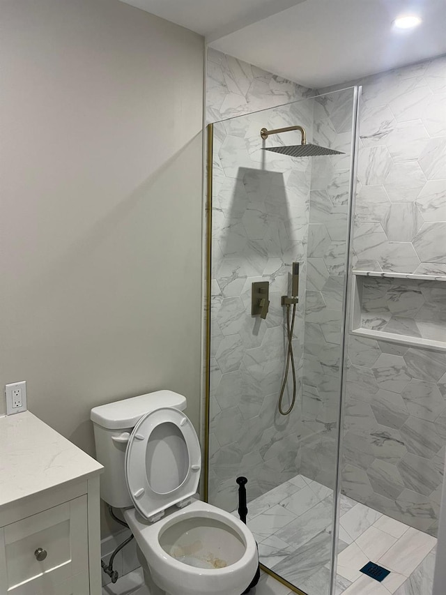 bathroom featuring vanity, toilet, and tiled shower