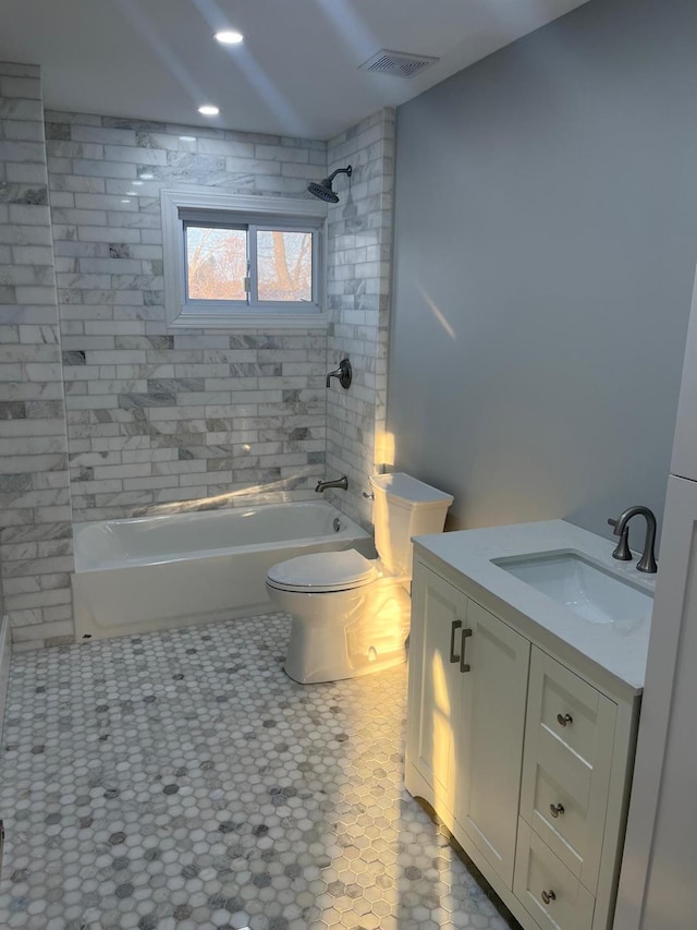 full bathroom featuring vanity, tile patterned flooring, tiled shower / bath combo, and toilet