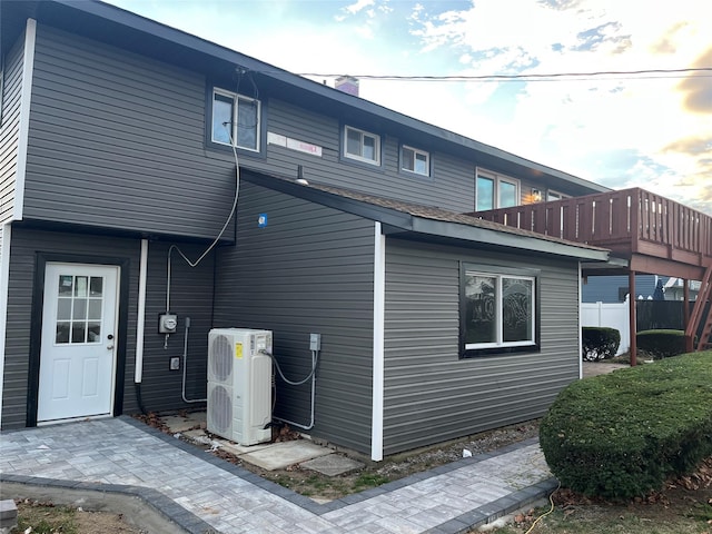 view of side of home with ac unit