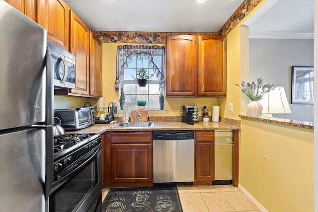 kitchen featuring sink, crown molding, stainless steel appliances, light stone counters, and light tile patterned flooring