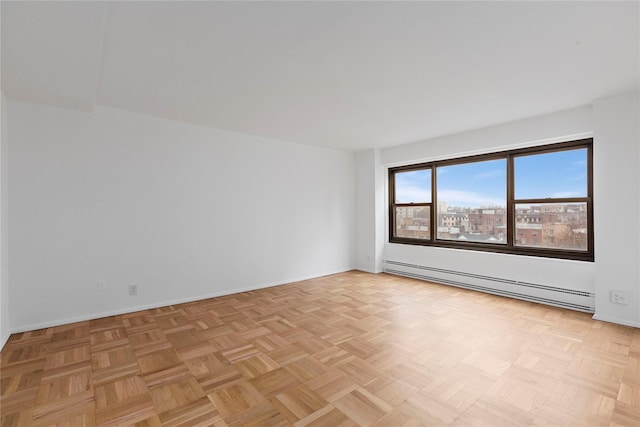 spare room with light parquet flooring and a baseboard radiator