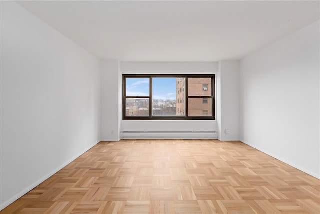 spare room with light parquet flooring and a baseboard radiator