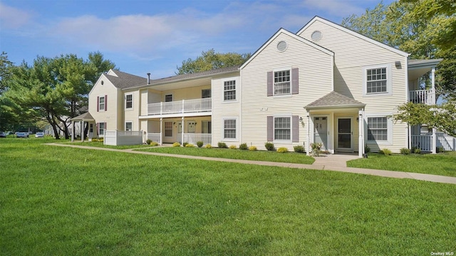 view of front of home with a balcony and a front yard